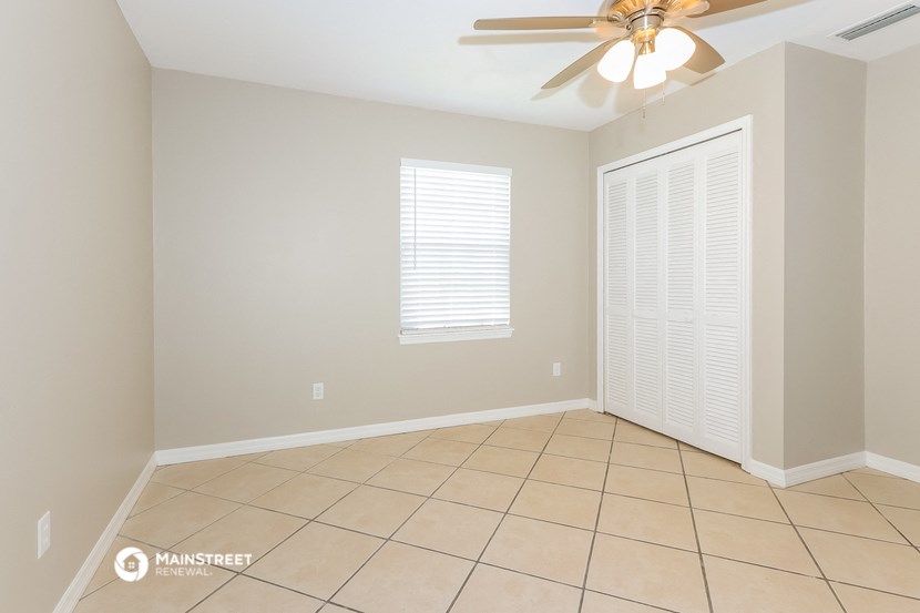 the living room has a tile floor and a ceiling fan