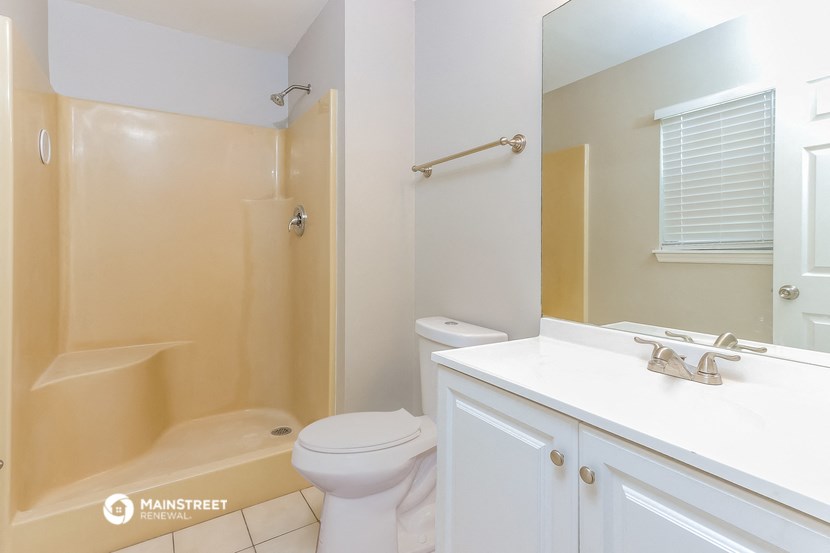 a bathroom with a shower toilet and sink and a mirror