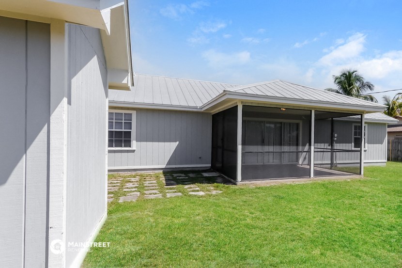 a white house with a porch and a grass yard