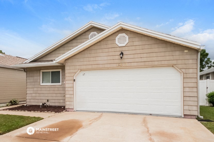 a tan house with a white garage door