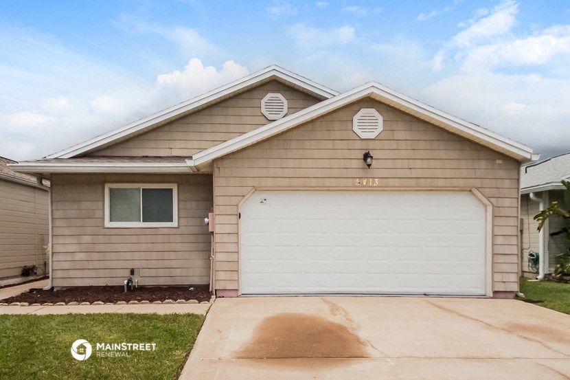 a tan house with a white garage door