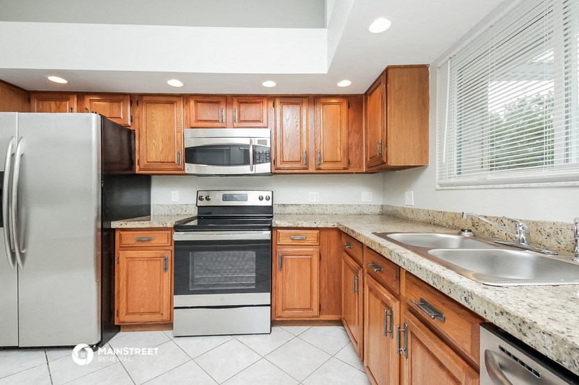 a kitchen with wooden cabinets and stainless steel appliances