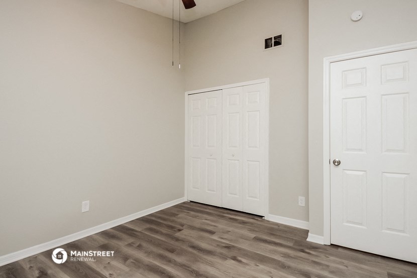 a bedroom with two white doors and a door to a closet