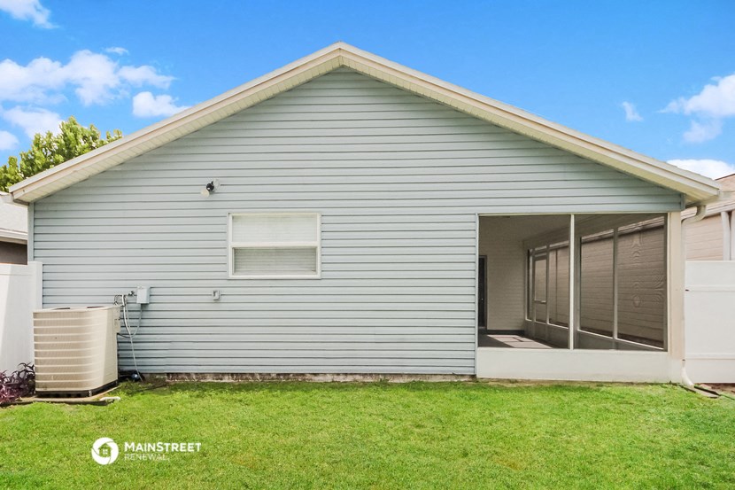 the outside of a gray house with a grassy yard