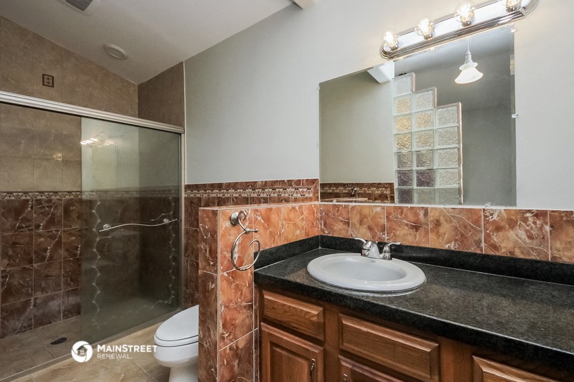 a bathroom with a sink and a shower and a mirror