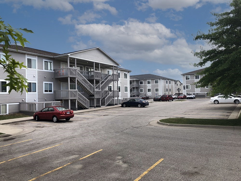 an empty parking lot in front of an apartment building