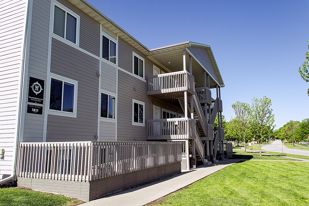 a gray house with a porch and a sidewalk