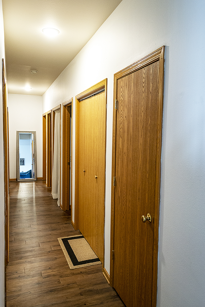 a row of closets in a room with wood floors and white walls