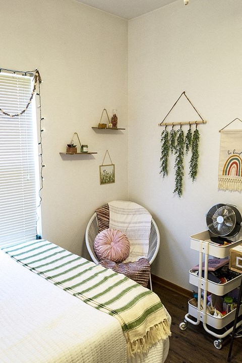 a bedroom with a bed and a chair in it