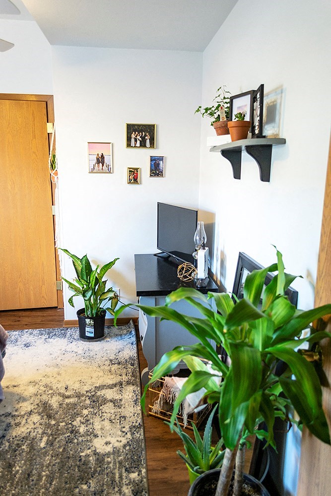 a living room with a desk and plants