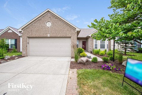 a brick house with a garage door and a driveway