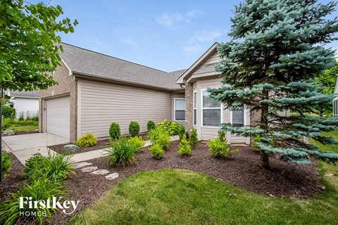 a home with a landscaped front yard and trees