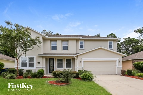a beige house with a lawn in front of it