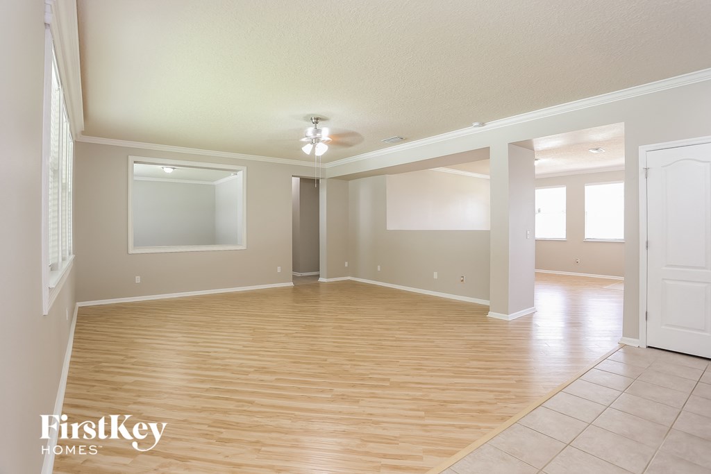 the living room and dining room with hardwood flooring and a ceiling fan