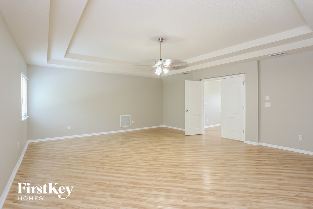 a spacious living room with wood flooring and a ceiling fan