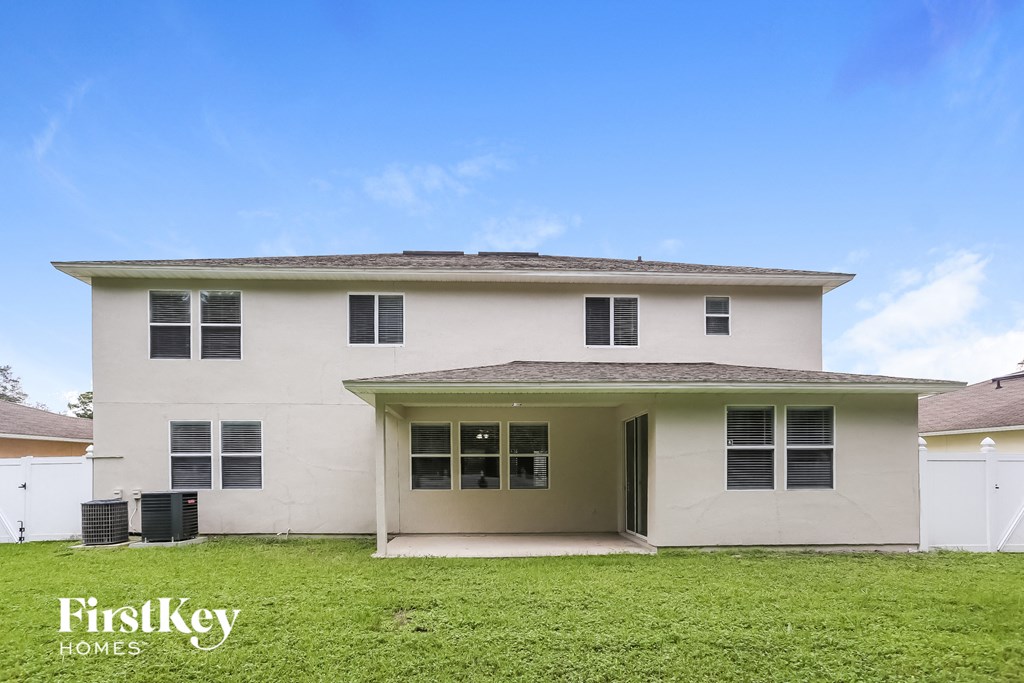 a white house with green grass and a blue sky