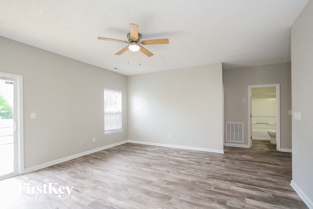 the living room of an empty house with a ceiling fan