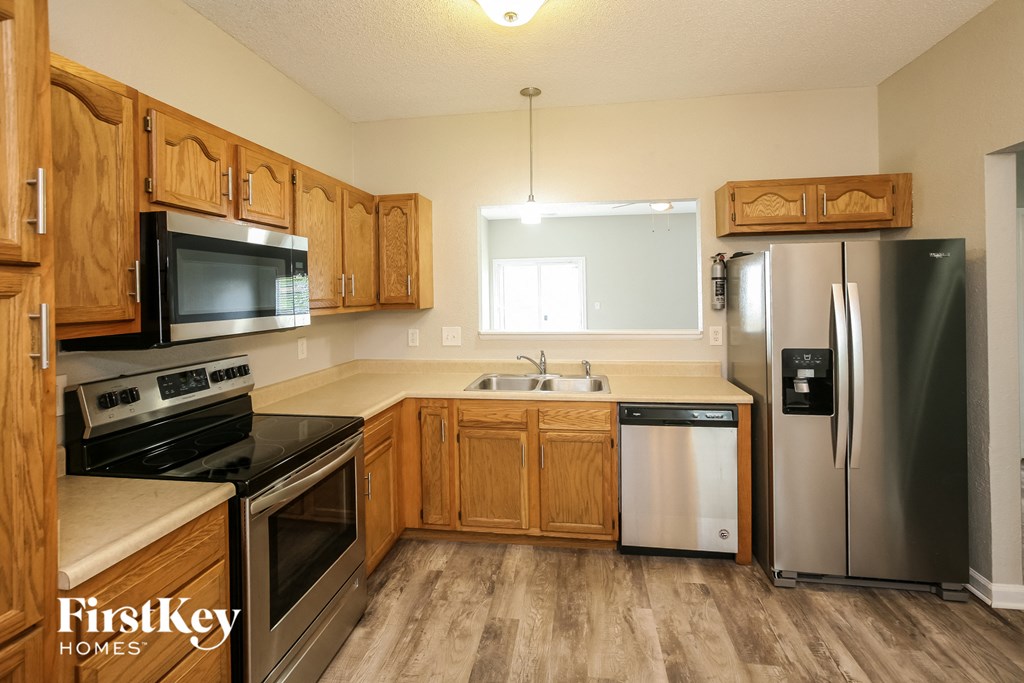 a kitchen with wooden cabinets and stainless steel appliances