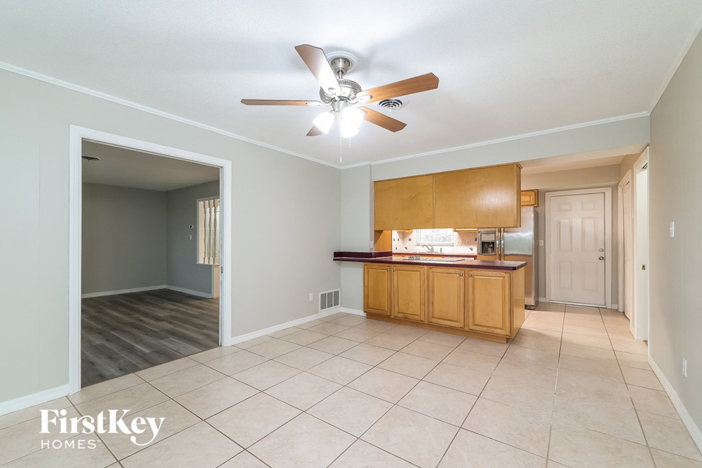 A spacious room with a ceiling fan and a reception desk.