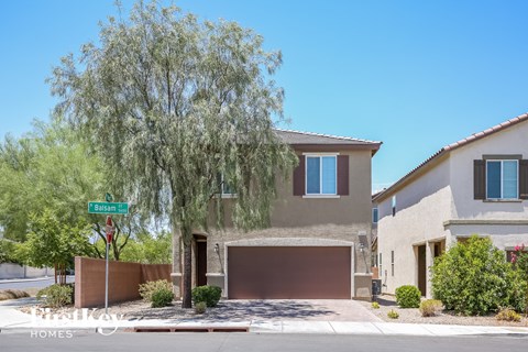 a house with a street sign in front of it and a tree