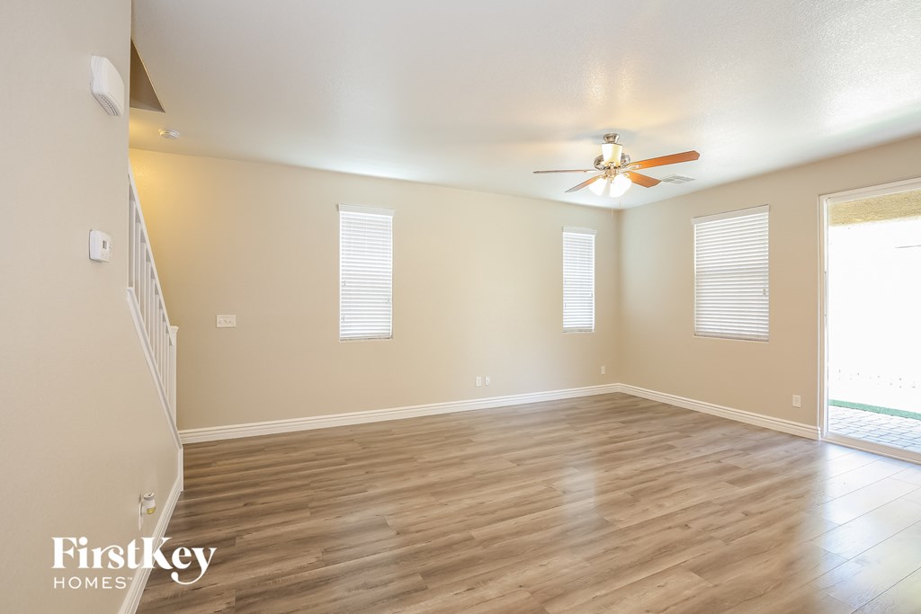 a living room with wood floors and a ceiling fan