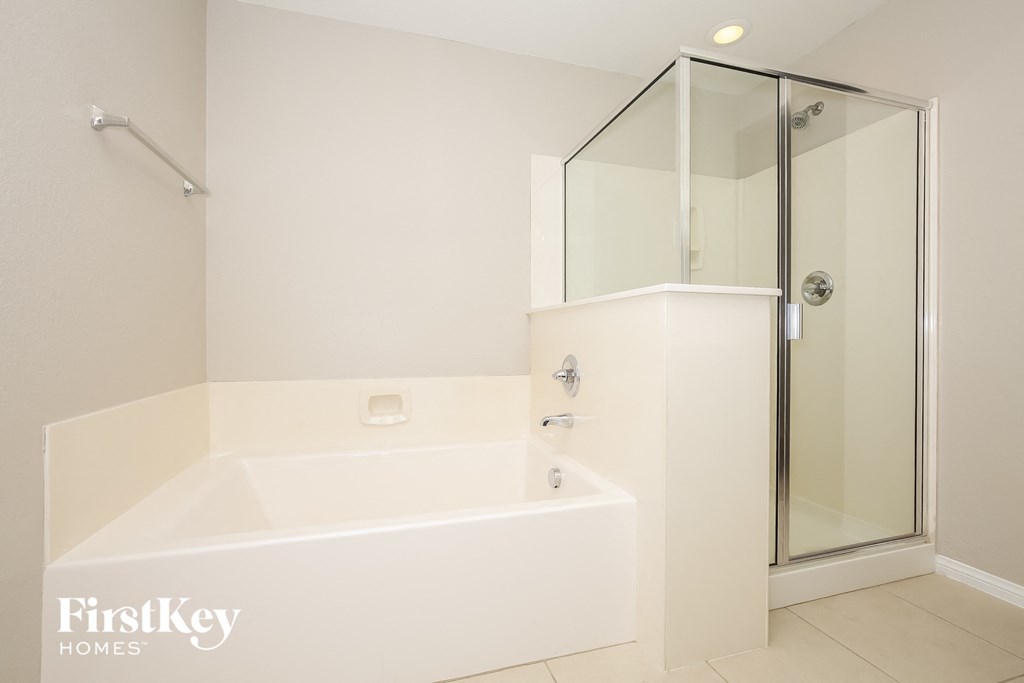 a white bathroom with a tub and a shower