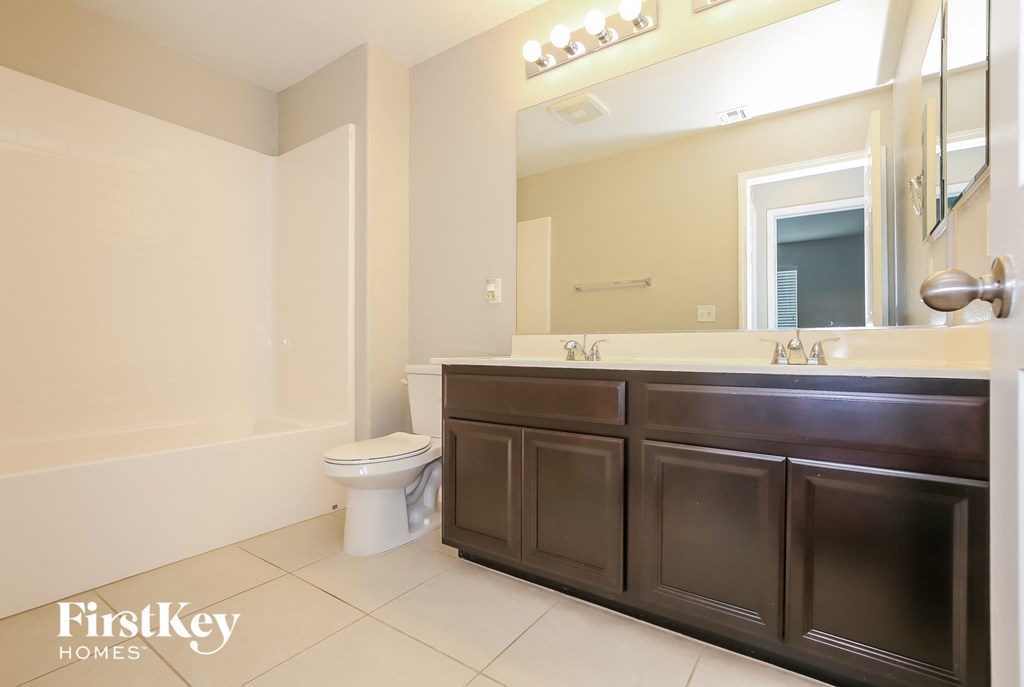 a bathroom with a toilet and a sink and a mirror