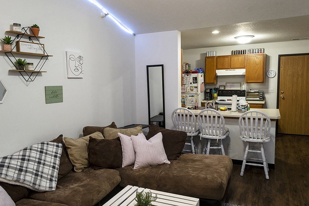 a living room with a couch and a kitchen with a table