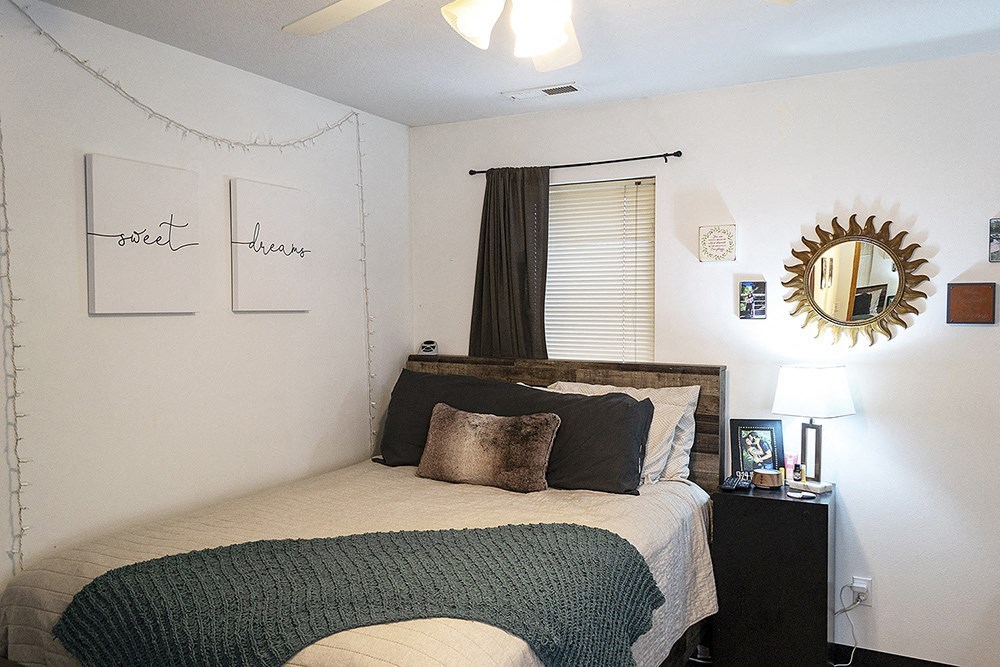 a bedroom with a bed and a mirror on the wall