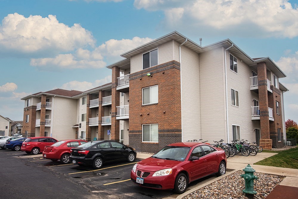 a row of cars parked in front of an apartment building