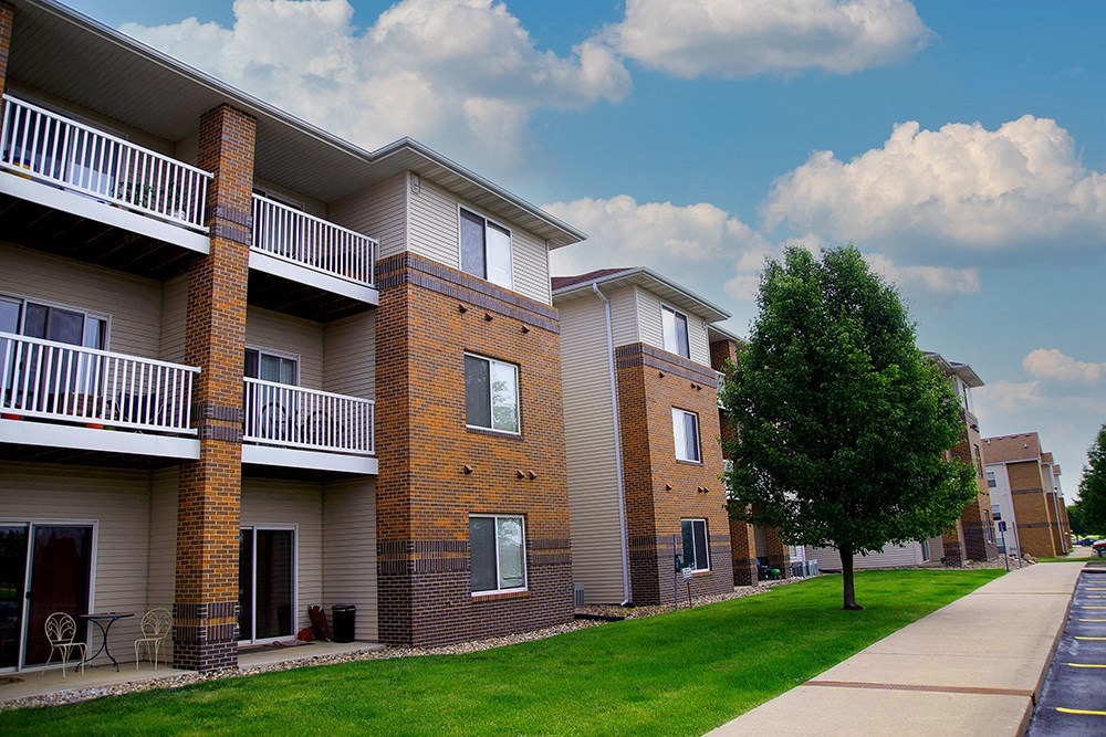 a row of brick and white apartment buildings on a sidewalk