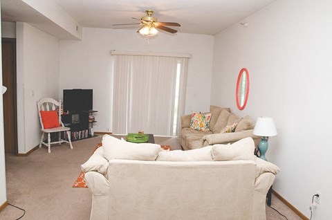a living room with a couch and a ceiling fan