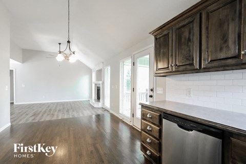 a kitchen and living room with wood floors and white walls