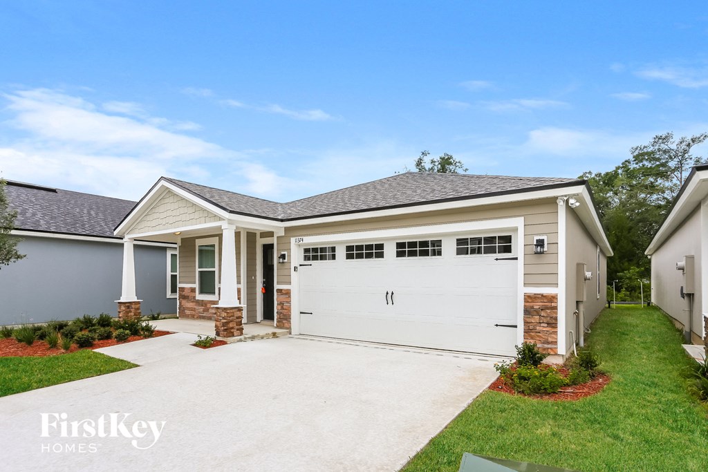 a suburban house with a white garage door and a driveway