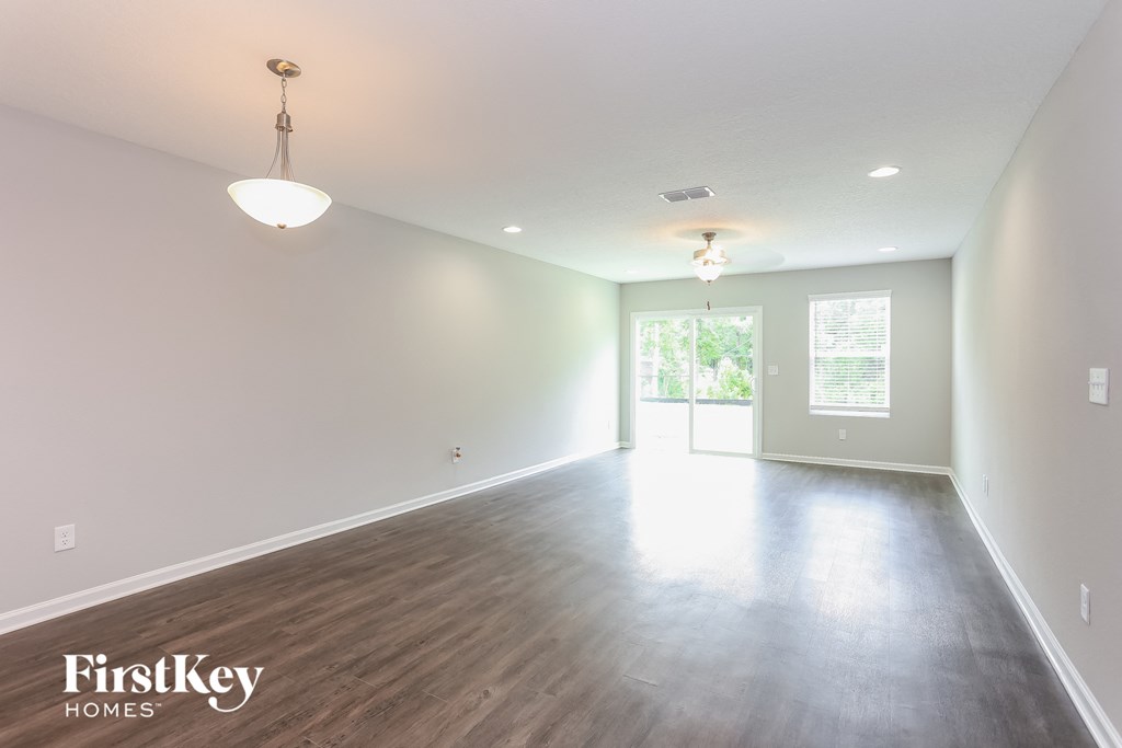 an empty living room with white walls and wood floors