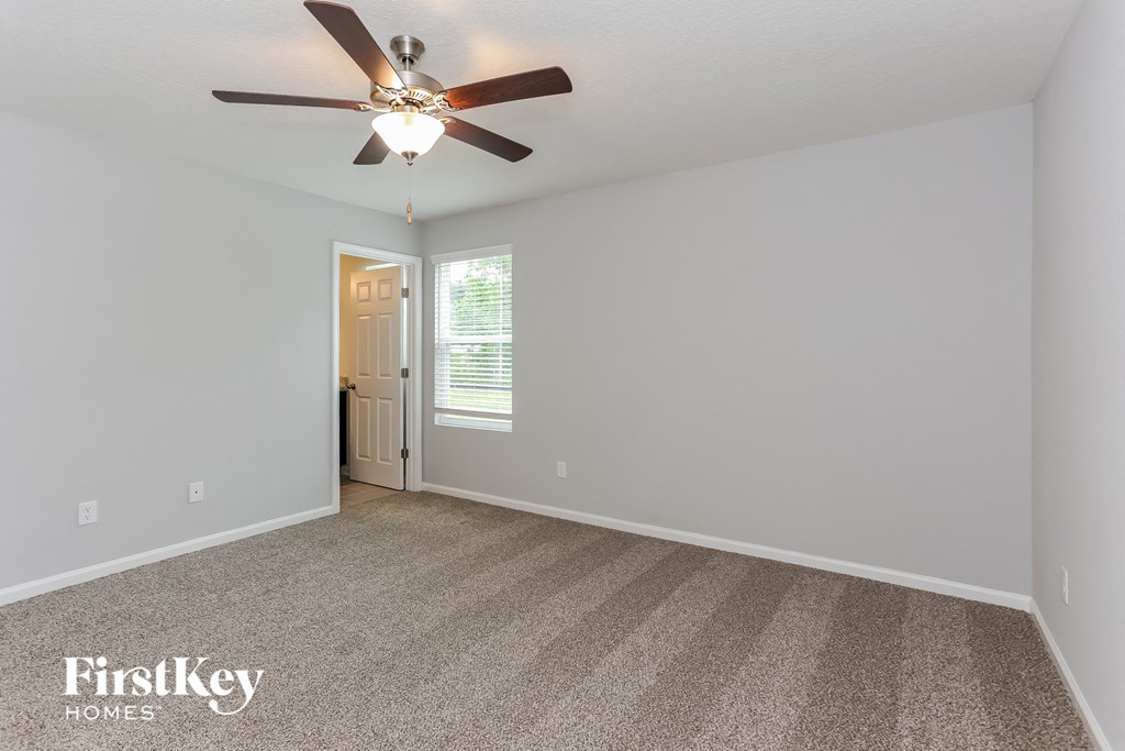 the master bedroom has a ceiling fan and carpeted flooring