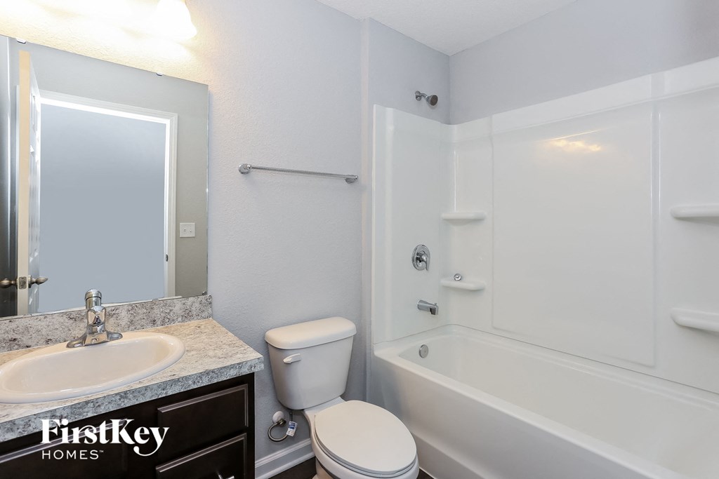 a bathroom with a toilet and a tub and a sink
