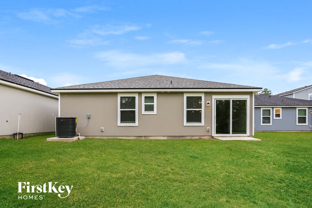 the backyard of a house with a lawn and a backdoor
