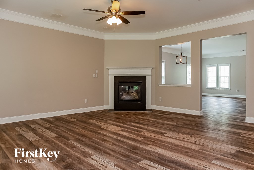 a living room with a fireplace and a ceiling fan