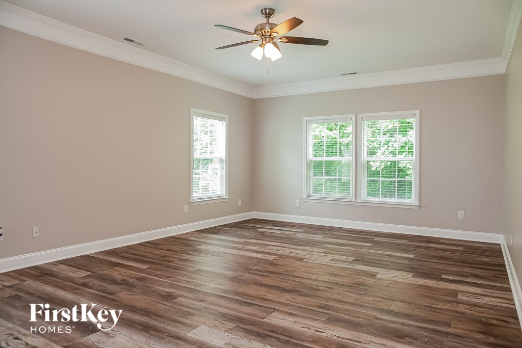 a living room with wood floors and a ceiling fan