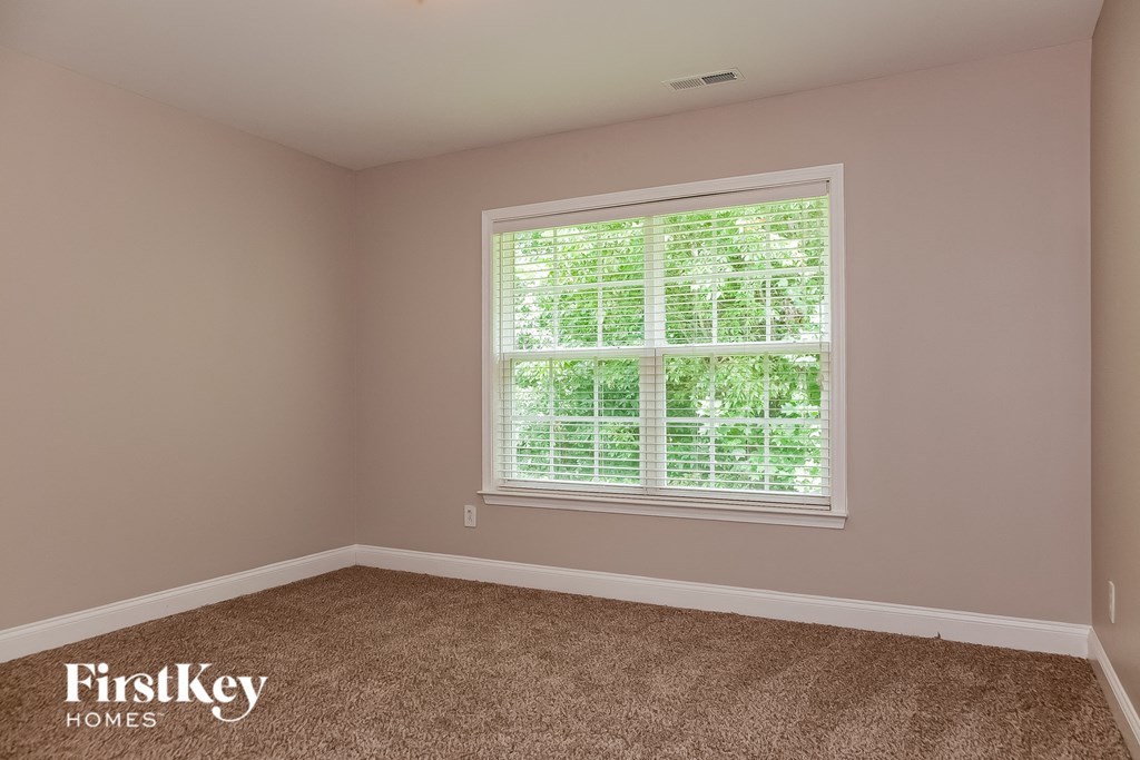 a empty room with a window and carpet