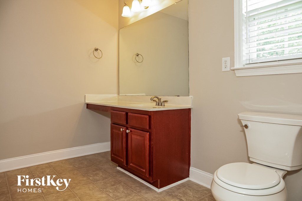 a bathroom with a toilet and a sink and a mirror