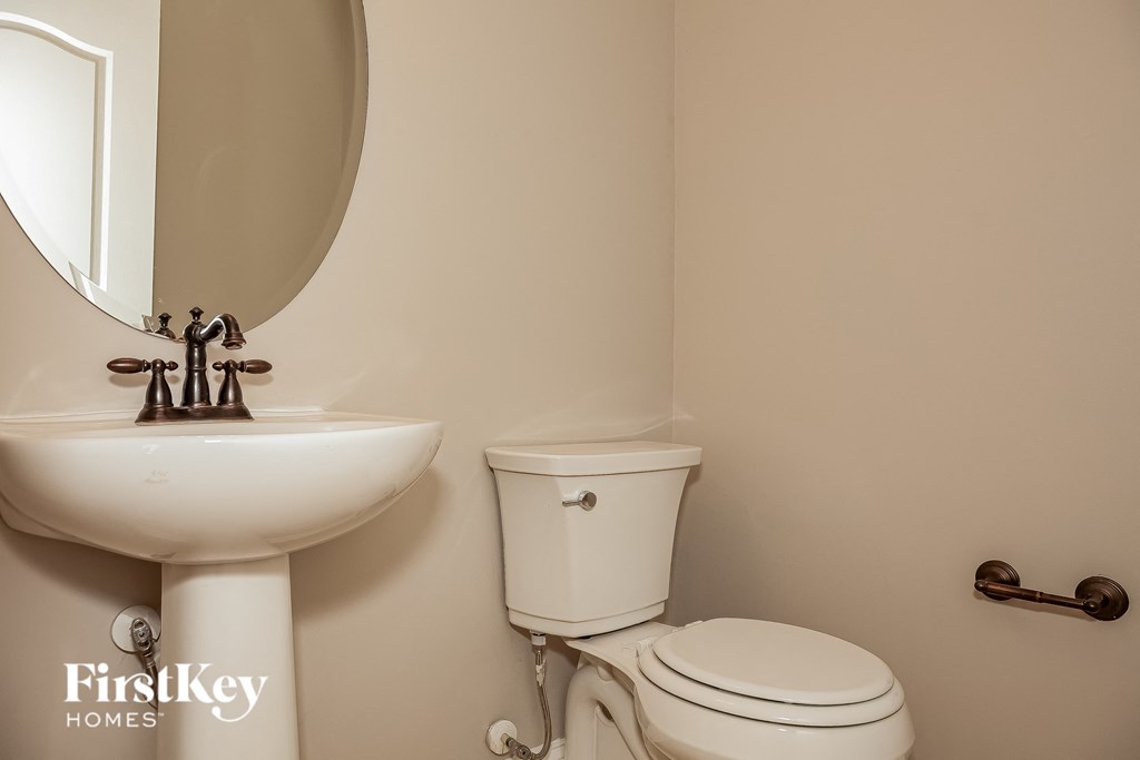 a bathroom with a toilet and a sink and a mirror