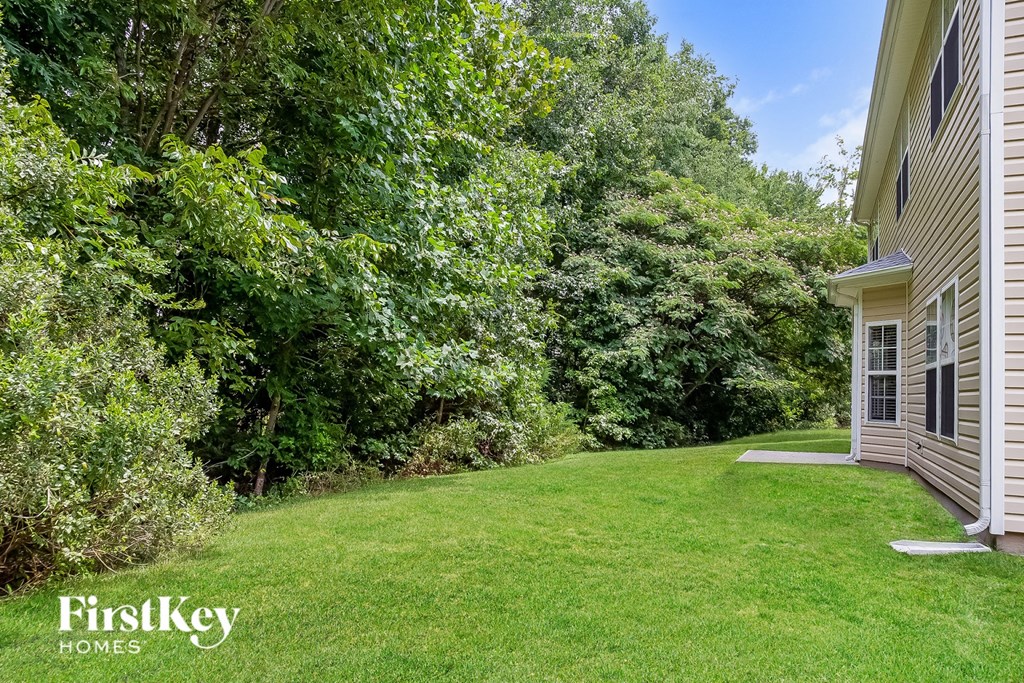 a yard next to a house and some trees