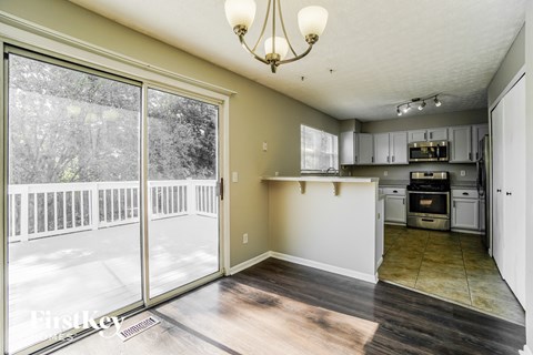 A kitchen with a dining table and chairs is visible from the living room.