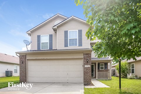 a house with a white garage door and a tree
