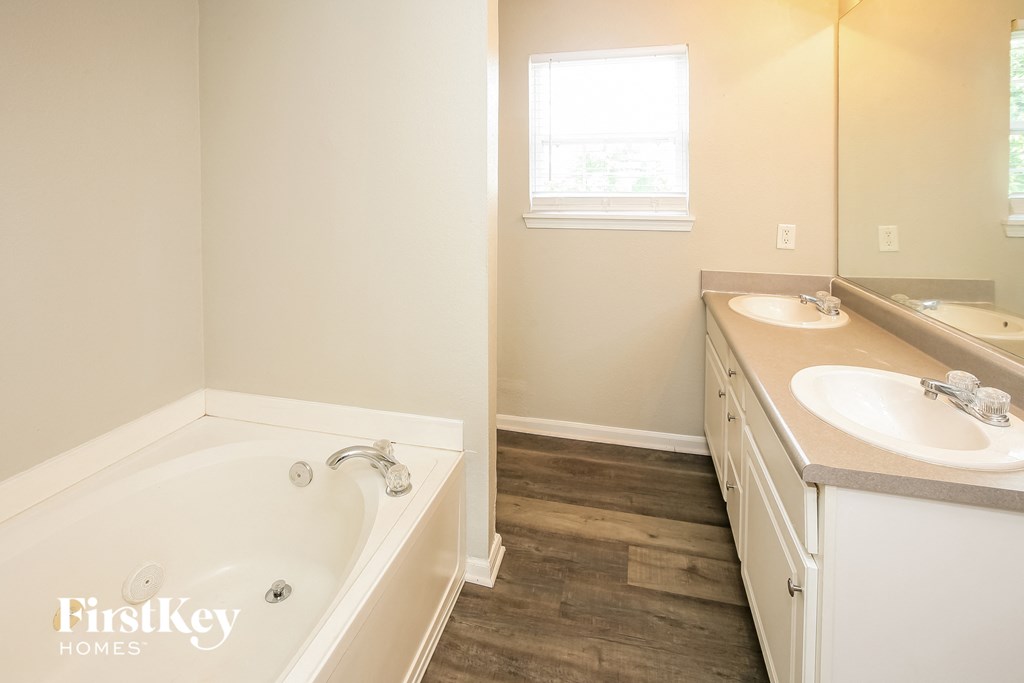 a bathroom with a tub and a sink and a mirror