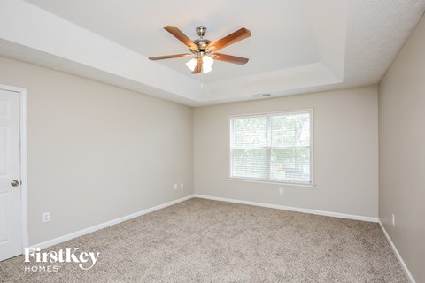 a bedroom with carpet and a ceiling fan