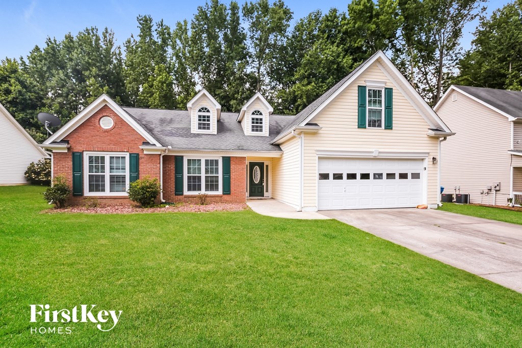 a white house with green shutters and a lawn
