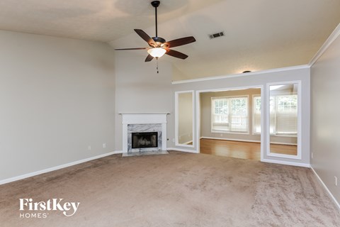 a living room with a fireplace and a ceiling fan